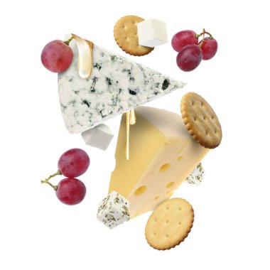 Peynir ürünleri beyaz arka planda havada. Farklı peynir, üzüm, kraker ve bal çeşitleri.