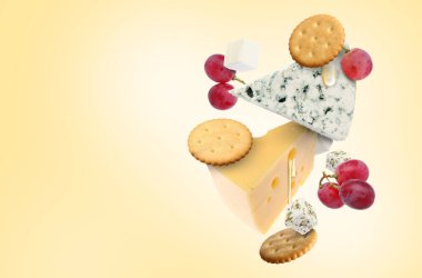 Bej renkli arka planda havadaki peynir ürünleri. Farklı peynir, üzüm, kraker ve bal çeşitleri.