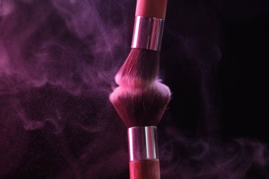 Siyah arka planda pembe göz farlı makyaj fırçaları, yakın plan