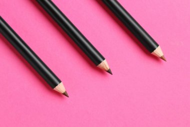 Farklı kaş kalemleri parlak pembe arka planda, düz yerde. Metin için boşluk