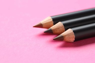 Pembe arka planda farklı kaş kalemleri, yakın plan. Metin için boşluk