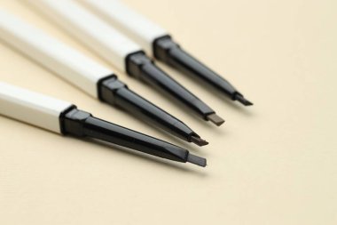 Bej arka planda otomatik kaş kalemleri, yakın plan