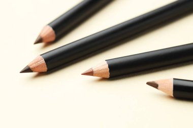 Bej arka planda farklı kaş kalemleri, yakın plan.