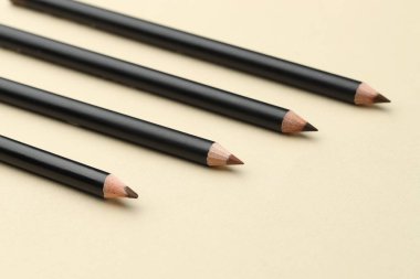 Bej arka planda farklı kaş kalemleri, yakın plan.