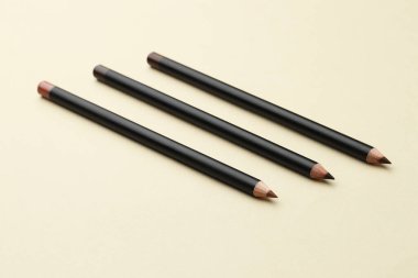 Bej arka planda farklı kaş kalemleri, yakın plan.