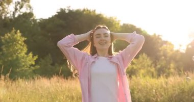 Özgürlüğü hissetmek. Mutlu genç bir kadın doğanın tadını çıkarıyor. Kamera hareket ediyor