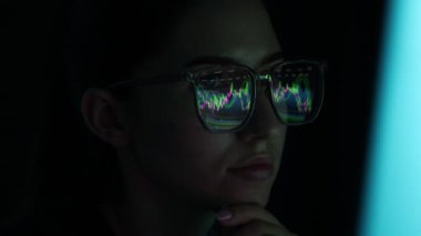 Siyah arka planda yansıması olan gözlüklü genç bir kadın, yakın plan.