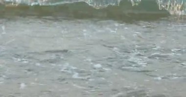 Kumlu sahilde güzel dalgalı deniz manzarası, yakın çekim.