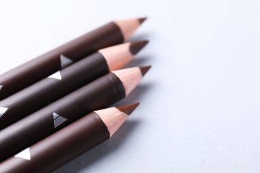 Beyaz arka planda bir sürü kaş kalemi var, yakın plan. Metin için boşluk