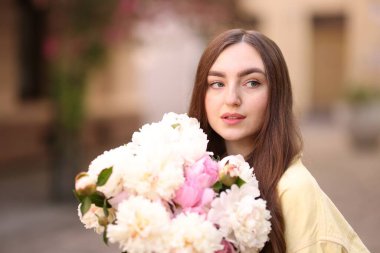 Şehir caddesinde elinde şakayık demeti olan bir kadın