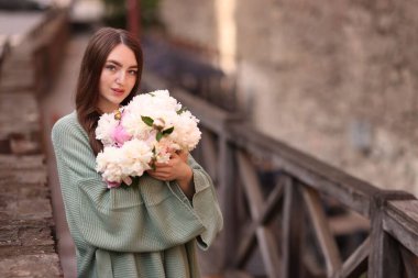 Şehir caddesinde bir buket güzel şakayığı olan çekici bir kadın. Metin için boşluk