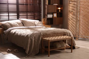 Yatak odasında güzel çarşafları olan rahat bir yatak.