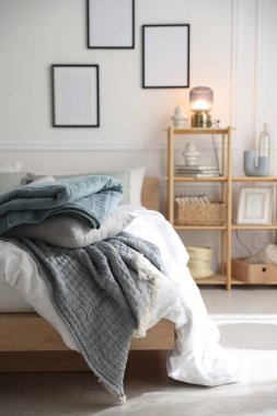 Yumuşak çarşafları olan rahat bir yatak ve şık bir odası olan bir raf. Ev tekstili