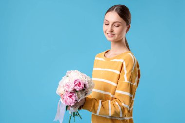 Açık mavi arka planda şakayık demeti olan güzel bir kadın, mesaj için yer var.