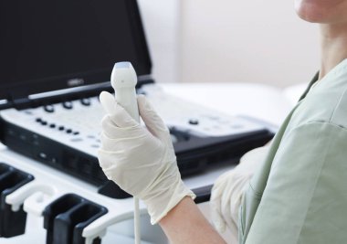 Klinikte ultrason makinesi olan profesyonel sonograf.