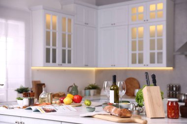 Şık bir mutfakta farklı ürünler ve bir şişe şarap.