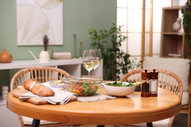 Lezzetli yemekler ve şık bir odada beyaz şarap olan yemek masası.