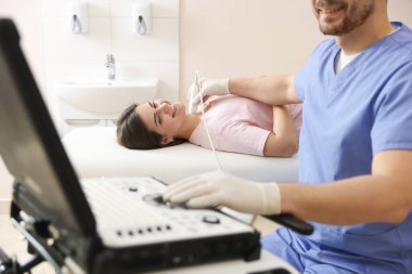 Sonograf klinikte kadının tiroid bezini ultrason taraması yapıyor.