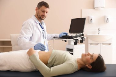 Klinikte kadın karın ultrasonu muayenesi yapan bir sonograf.