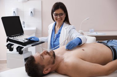 Sonograf klinikte bir adamın kalbinin ultrason muayenesi yapıyor.