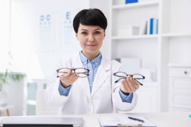 Klinikteki beyaz masadaki profesyonel göz doktorunun portresi