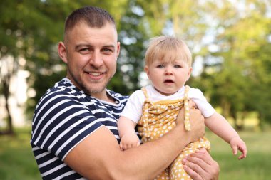 Gülümseyen baba ve bebeği dışarıda. Babalar Günün kutlu olsun.