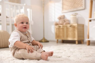 Işık odasında halının üzerinde oturan sevimli bebek. Metin için boşluk