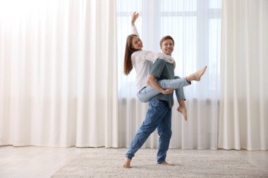 Mutlu genç çift evde dans ediyor. Metin için boşluk