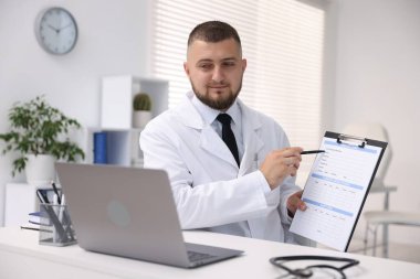 Klinikte bilgisayarla online danışmanlık yapan bir doktor