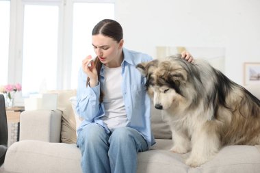 Evde köpeğine alerjisi olan bir kadın.