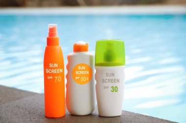 Güneş kremleri havuz kenarında şişelerde. Güneş koruma ürünü