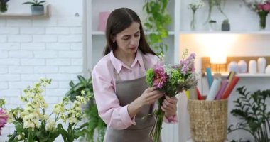 Profesyonel çiçekçi dükkanda çiçek buketi yapıyor.