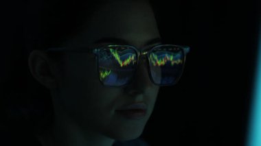 Siyah arka planda yansıması olan gözlüklü genç bir kadın, yakın plan.