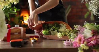 Profesyonel çiçekçi dükkanda çiçek buketi yapıyor, yakın plan.