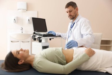 Klinikte kadın karın ultrasonu muayenesi yapan bir sonograf.