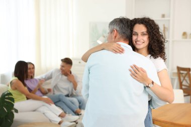 Mutlu arkadaşlar evde sarılıyor, seçici odaklanıyor.