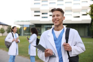 Sırt çantası ve defteriyle dışarıda tıp öğrencisi, seçici odaklanma.