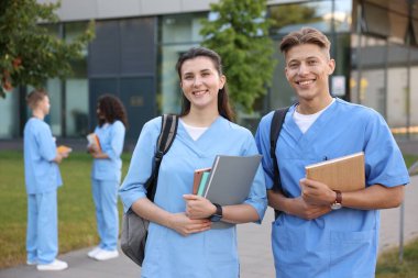 Dışarıda defterleri olan tıp öğrencileri, seçici bir odak noktası.