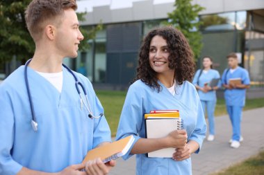 Dışarıda defterleri olan tıp öğrencileri, seçici bir odak noktası.