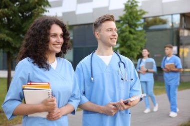 Dışarıda defterleri olan tıp öğrencileri, seçici bir odak noktası.