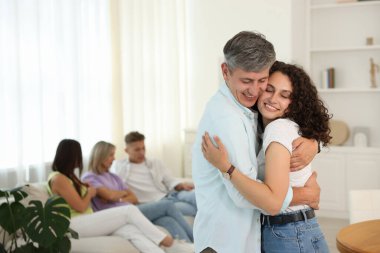 Mutlu arkadaşlar evde sarılıyor, seçici odaklanıyor.