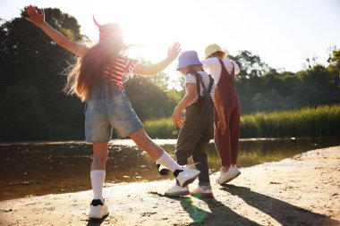 Tatlı küçük kızlar güneşli bir günde doğada vakit geçiriyorlar.