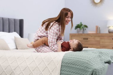 Mutlu anne oğluyla evde yatakta vakit geçiriyor.