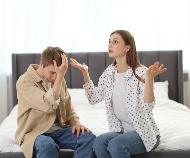 Bir erkek, evde yatarken karısından özür diliyor.