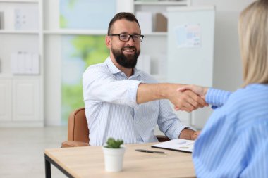 İş ortakları ofiste el sıkışıyor, yakınlaşıyor.