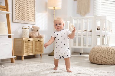 Işık odasında oyuncaklarla oynayan sevimli bebek.