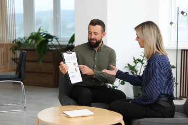 Ofiste belgelerle çalışan gülümseyen iş ortakları