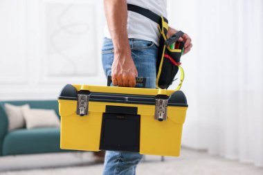 Kapalı mekanda alet çantası olan profesyonel bir tamirci.