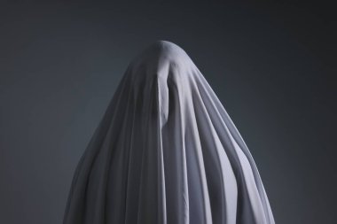 Ürkütücü hayalet. Açık gri arka planda beyaz çarşaflı adam