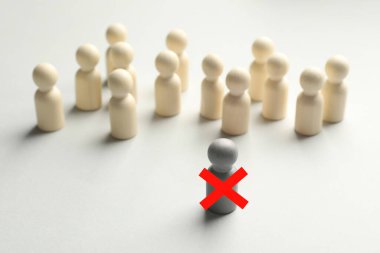 Dağılabilirsiniz. Bir gri insan figürü ve diğerleri arasında kırmızı haç beyaz masada.